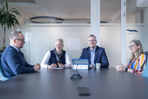 Das Team von HEB Steuerberatung sitzt gemeinsam an enem Besprechungstisch