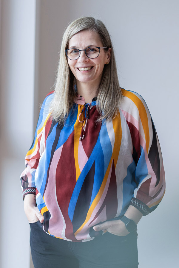 Nicole Buß steht in einem hellen Raum und lächelt in die Kamera